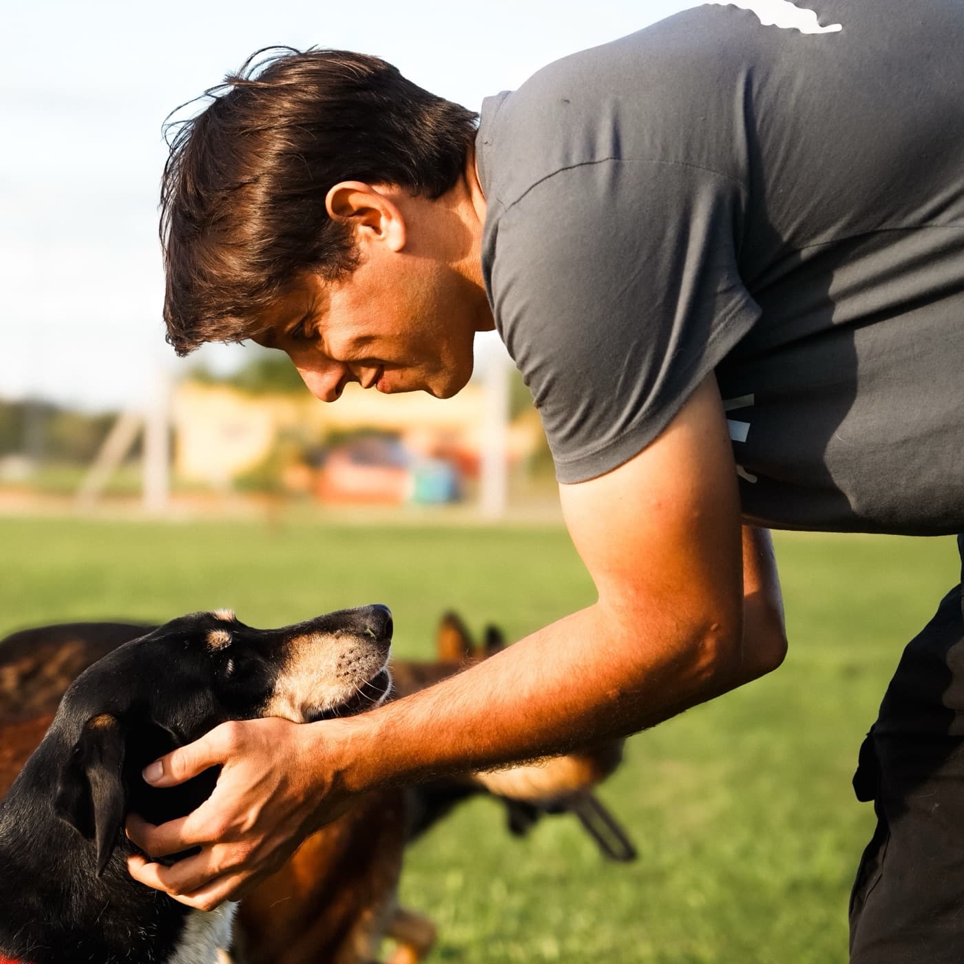 Germán Quiroga agachado acariciando la cabeza de un perro en un parque